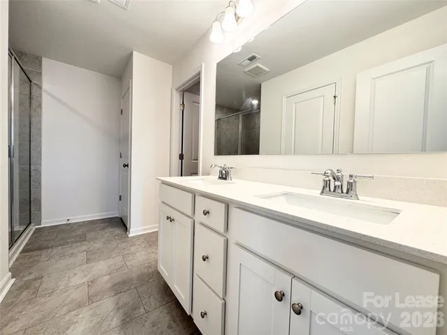 a spacious bathroom with double sink and a mirror