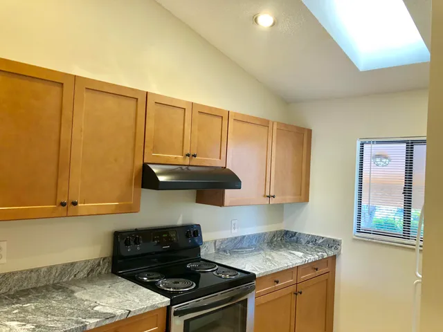 a kitchen with granite countertop cabinets and black appliances