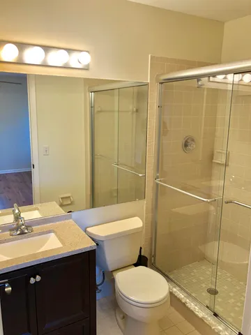 a bathroom with a sink a toilet and shower