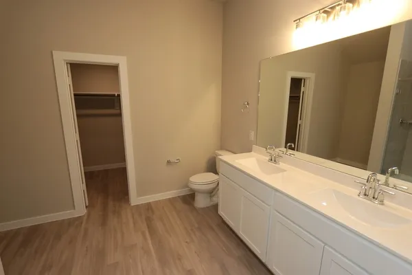 a bathroom with a granite countertop sink toilet and mirror