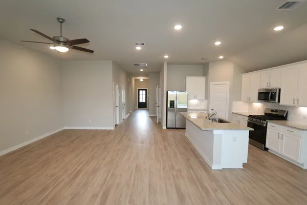 a view of kitchen with stainless steel appliances refrigerator stove microwave and cabinets