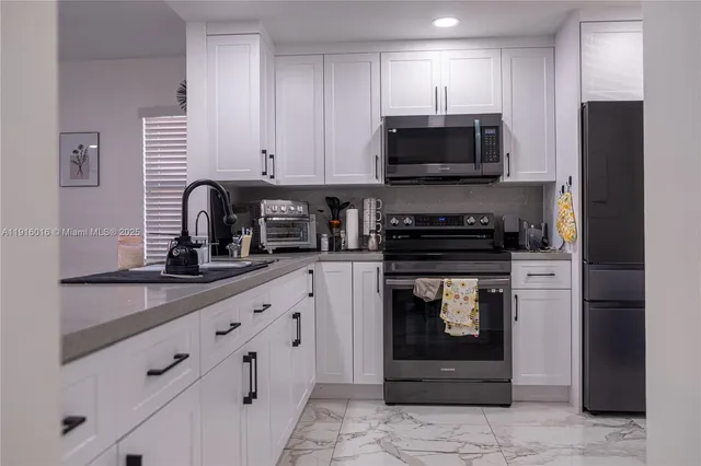 a kitchen with white cabinets and stainless steel appliances
