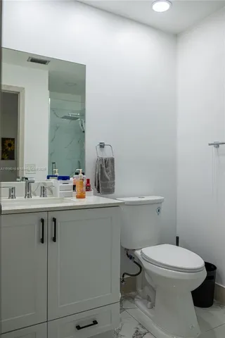 a bathroom with a toilet a sink and mirror