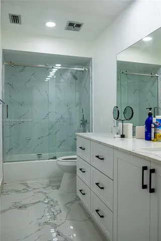 a bathroom with a double vanity sink toilet and shower