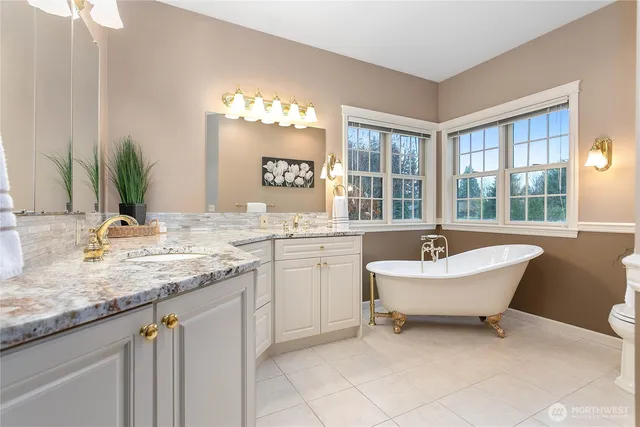 a bathroom with a granite countertop sink mirror and a bathtub
