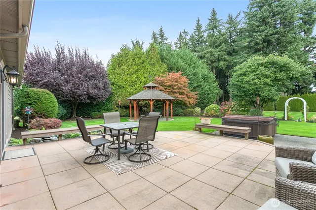 a view of a patio with table and chairs and potted plants with wooden fence