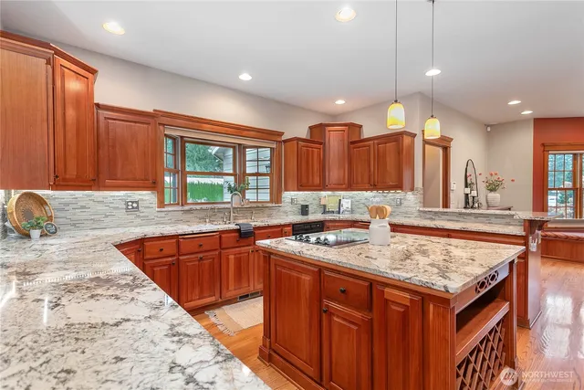 a kitchen with stainless steel appliances granite countertop a sink stove and cabinets
