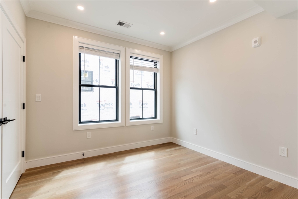 285 Lamartine Street, Unit 2 Boston, MA 02130 - Photo 4 of 13 an empty room with wooden floor and windows