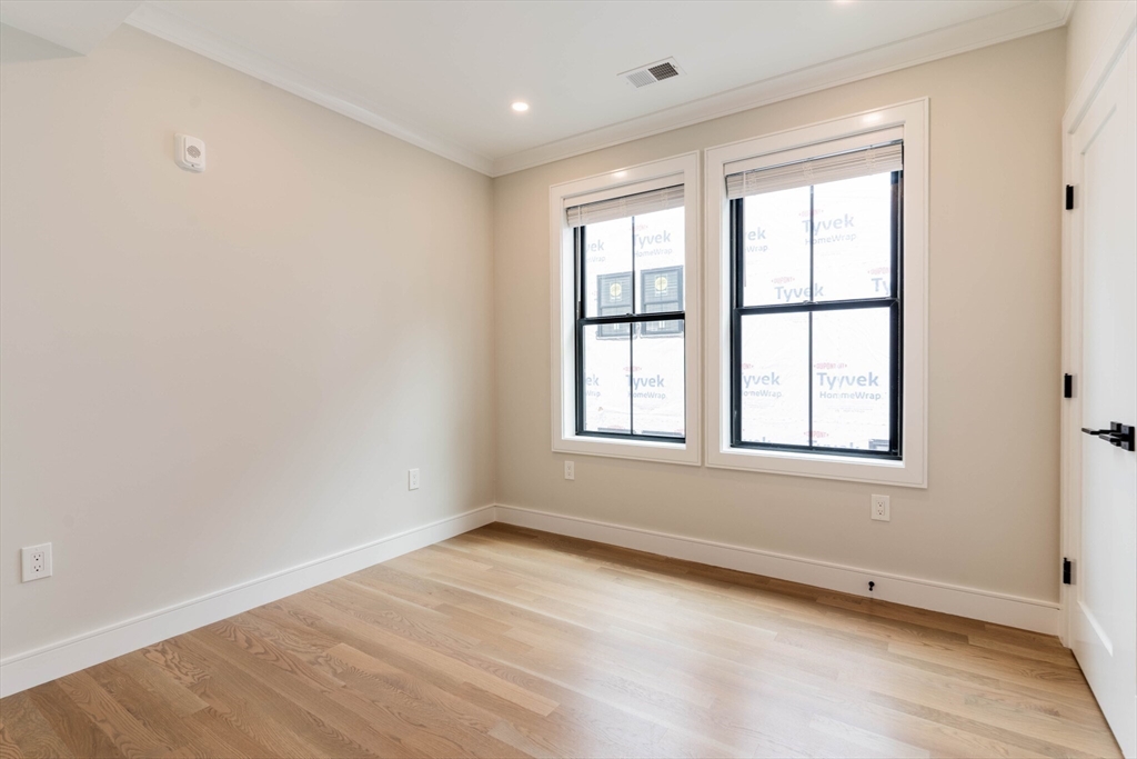 285 Lamartine Street, Unit 2 Boston, MA 02130 - Photo 6 of 13 an empty room with wooden floor and windows