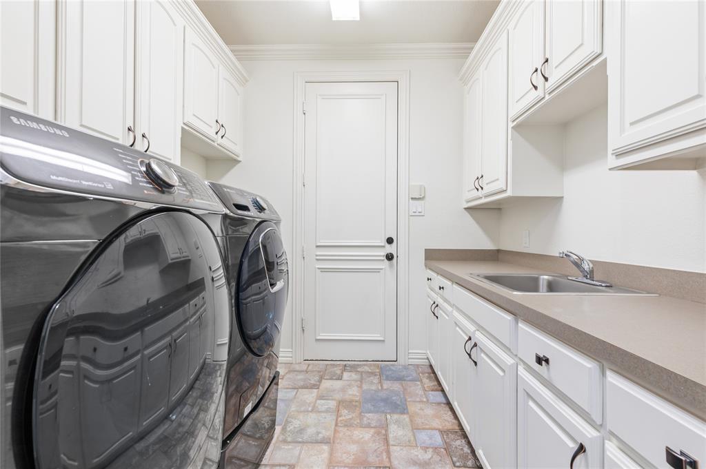 967 East Bethel School Road Coppell, TX 75019 - Photo 37 of 39 Laundry room with ample storage cabinetry, a utility sink, and durable flooring