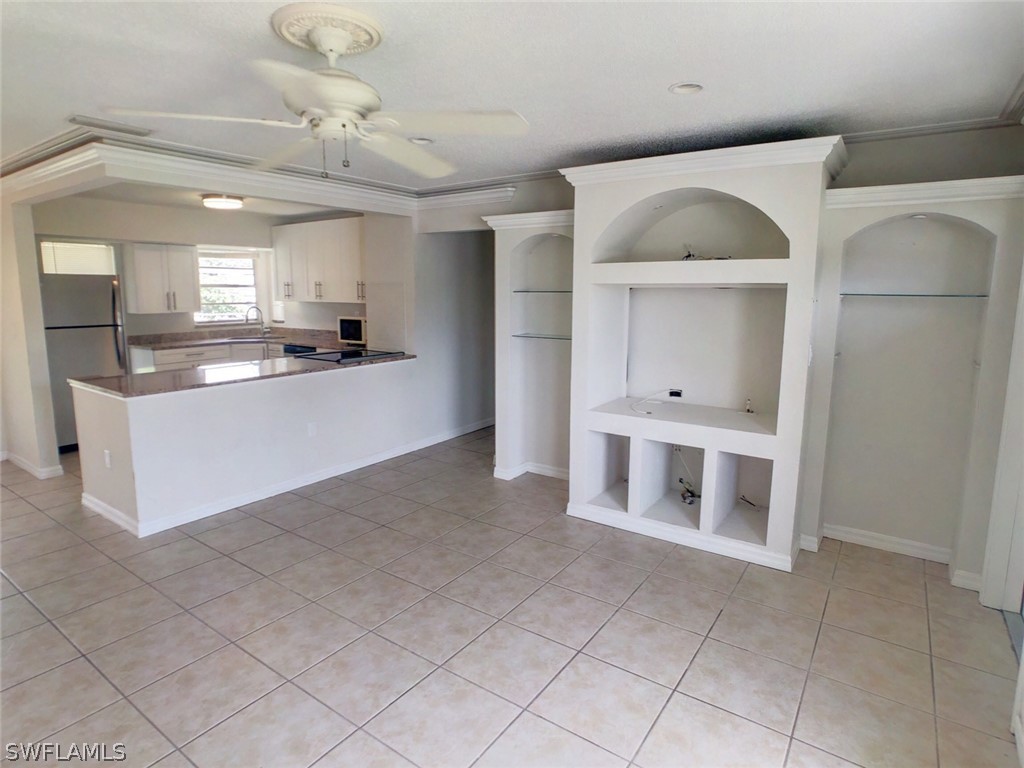 18577 Iris Road Fort Myers, FL 33967 - Photo 2 of 16 a large white kitchen with cabinets a sink a window and stainless steel appliances