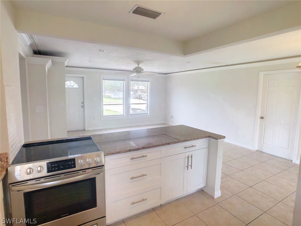 18577 Iris Road Fort Myers, FL 33967 - Photo 4 of 16 a kitchen with granite countertop white cabinets and white appliances