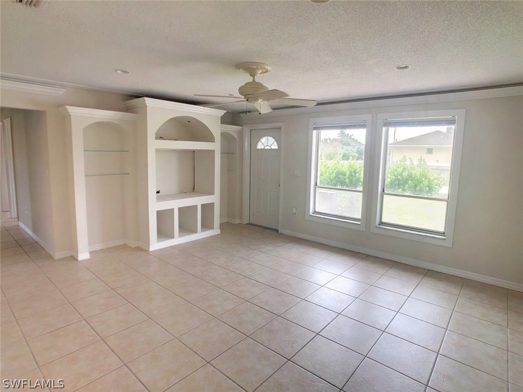 18577 Iris Road Fort Myers, FL 33967 - Photo 5 of 16 an empty room with windows and fan
