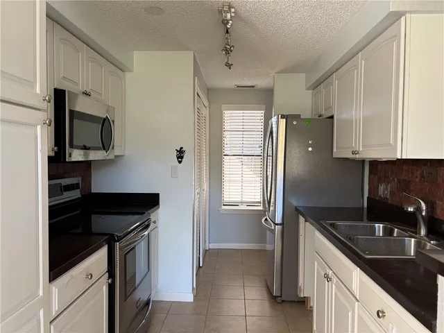 a kitchen with granite countertop a refrigerator and a sink