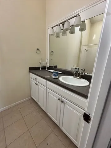 a bathroom with a granite countertop toilet sink and mirror