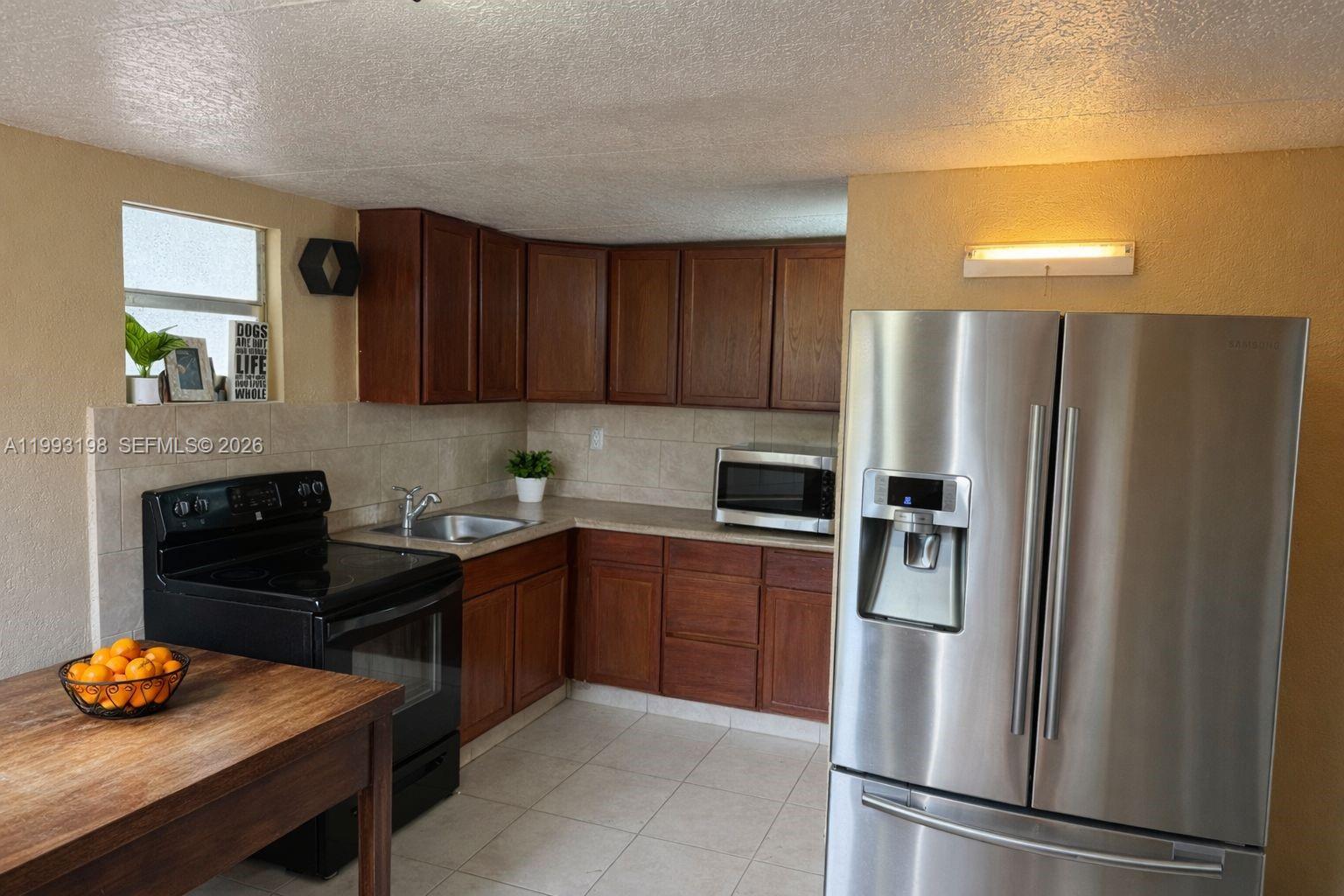 2353 Southwest 2nd Street Miami, FL 33135 - Photo 4 of 7 a kitchen with stainless steel appliances granite countertop a refrigerator and a stove top oven