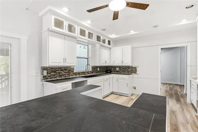 a view of kitchen with stainless steel appliances granite countertop white cabinets and sink