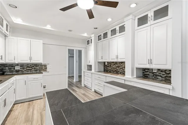 a kitchen with stainless steel appliances granite countertop a stove and white cabinets