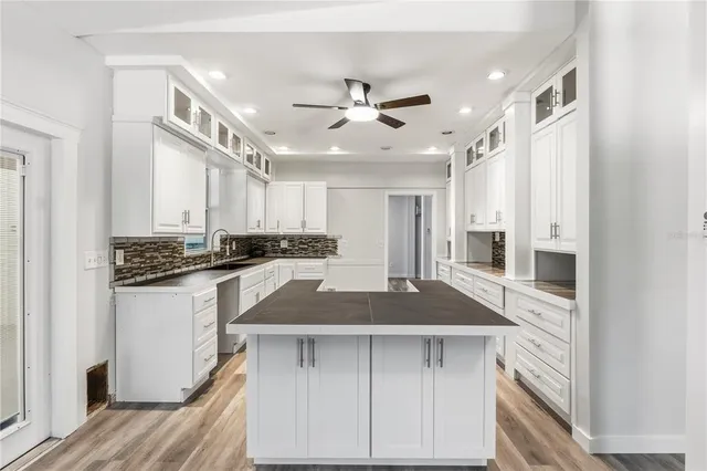 a view of a kitchen with wooden floor and a ceiling fan