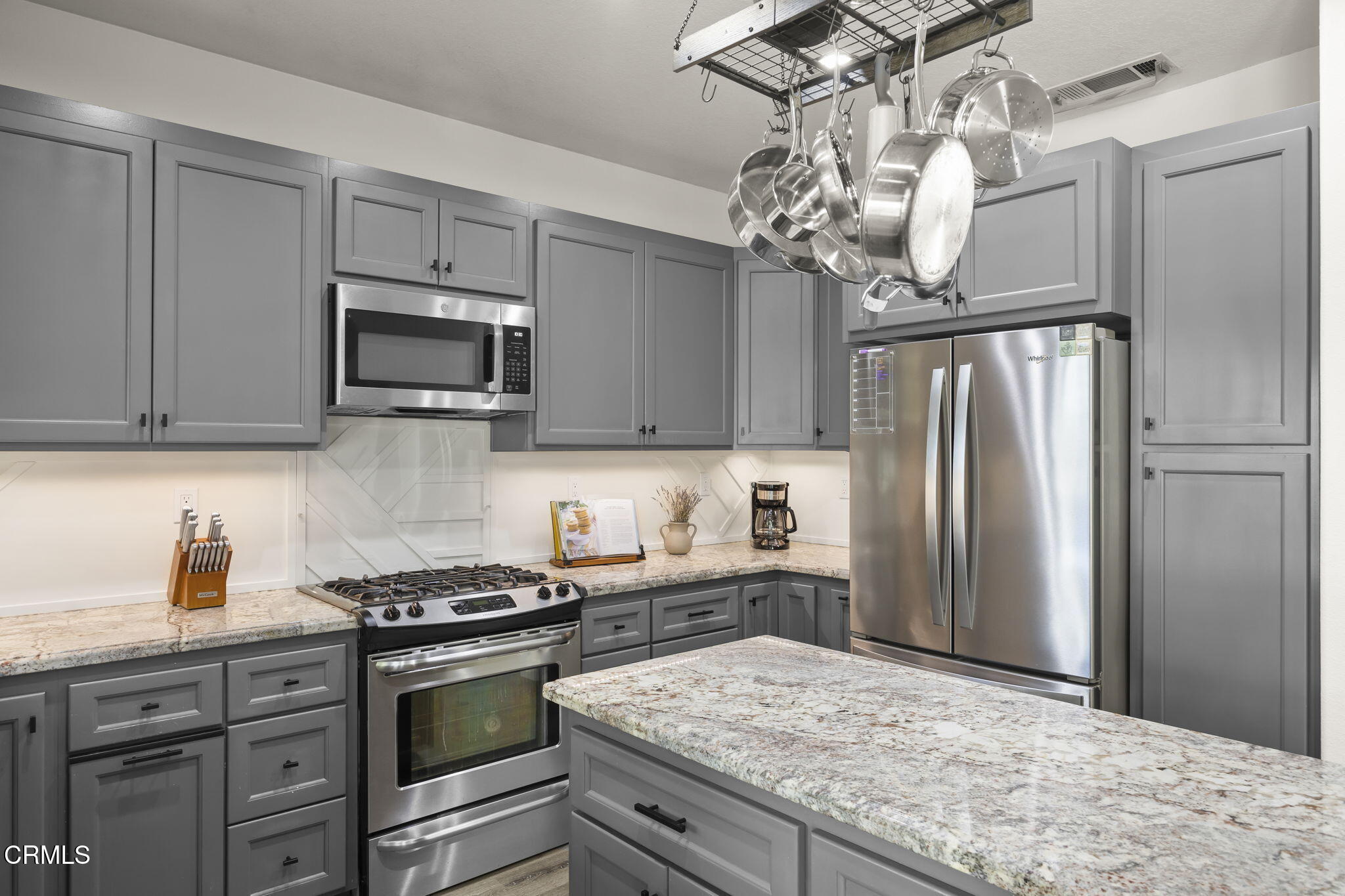 803 Noontide Way Oxnard, CA 93035 - Photo 15 of 44 a kitchen with stainless steel appliances granite countertop a refrigerator a stove a sink dishwasher a dining table and chairs with wooden floor