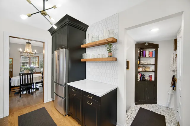a kitchen with stainless steel appliances granite countertop a refrigerator and a wooden cabinets