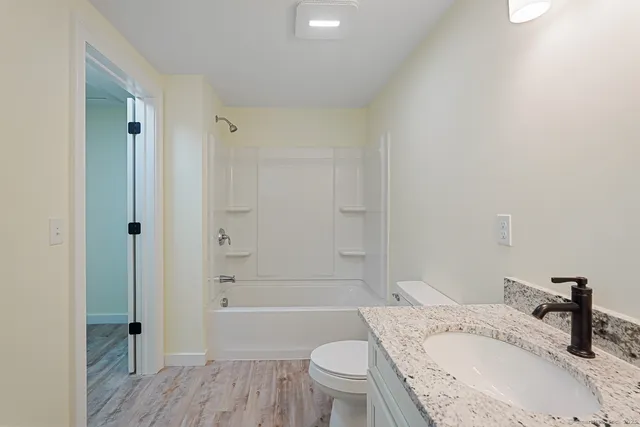 a bathroom with a granite countertop sink toilet and shower