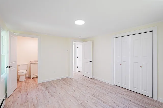 a view of a room with wooden floor and a bathroom