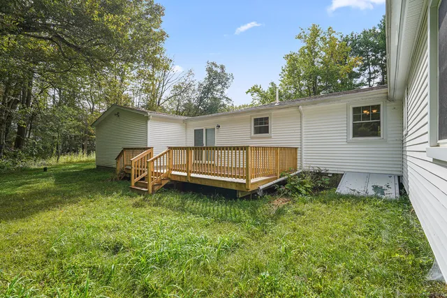 a backyard of a house with barbeque oven and trees