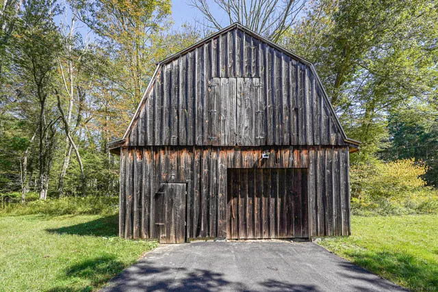 a view of a backyard with plants and wooden fence