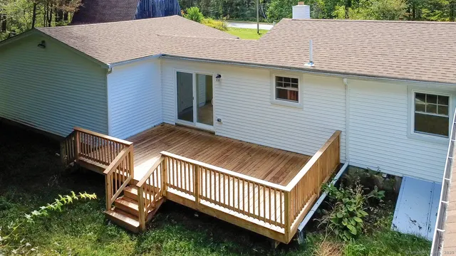 a view of a house with a yard and deck