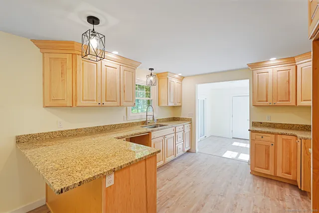 a kitchen with granite countertop cabinets stainless steel appliances and wooden floor