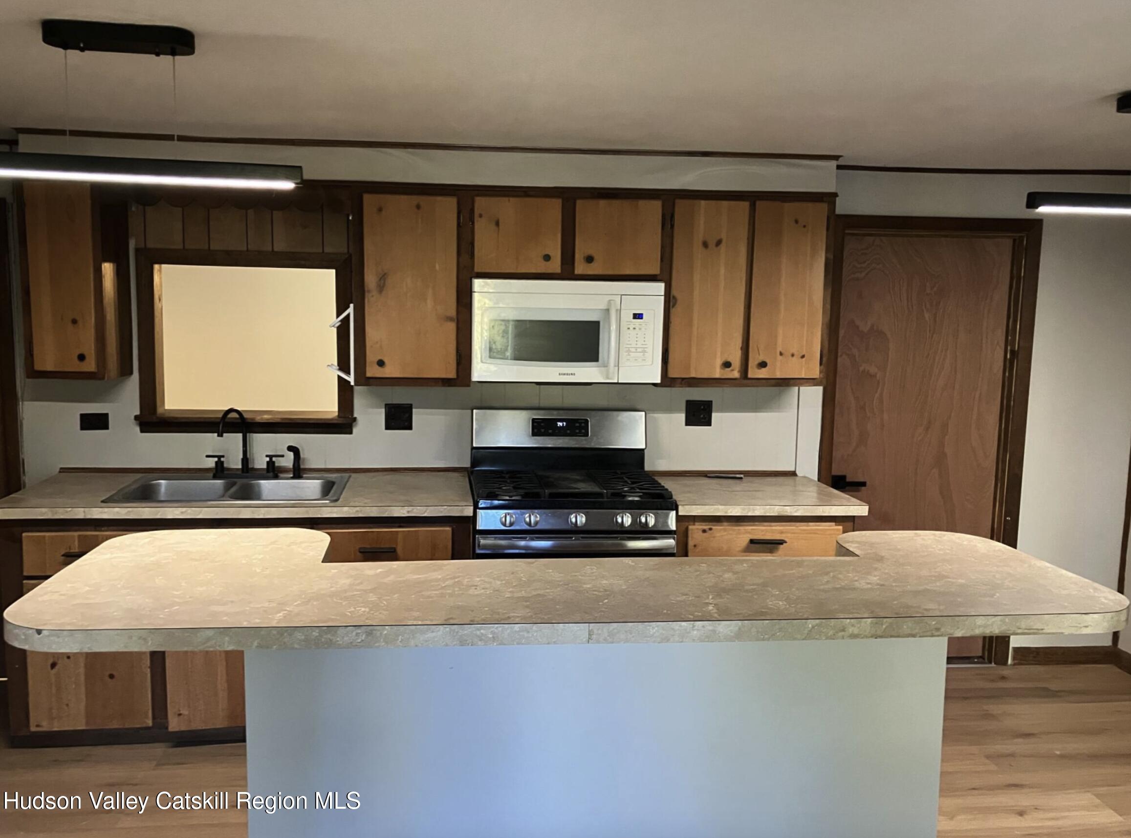 1072 Honey Hollow Road Earlton, NY 12058 - Photo 5 of 15 a kitchen with kitchen island granite countertop a sink and a stove top oven