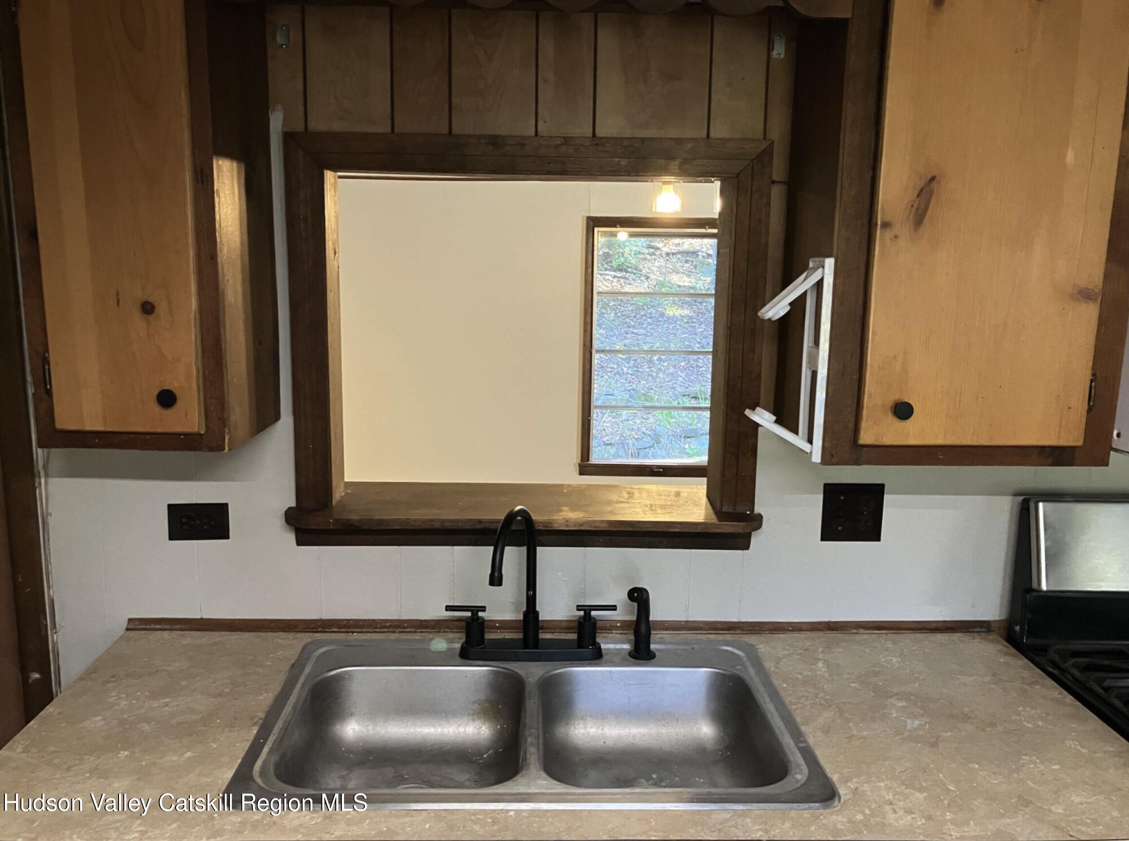 1072 Honey Hollow Road Earlton, NY 12058 - Photo 7 of 15 a kitchen with sink a window and cabinets