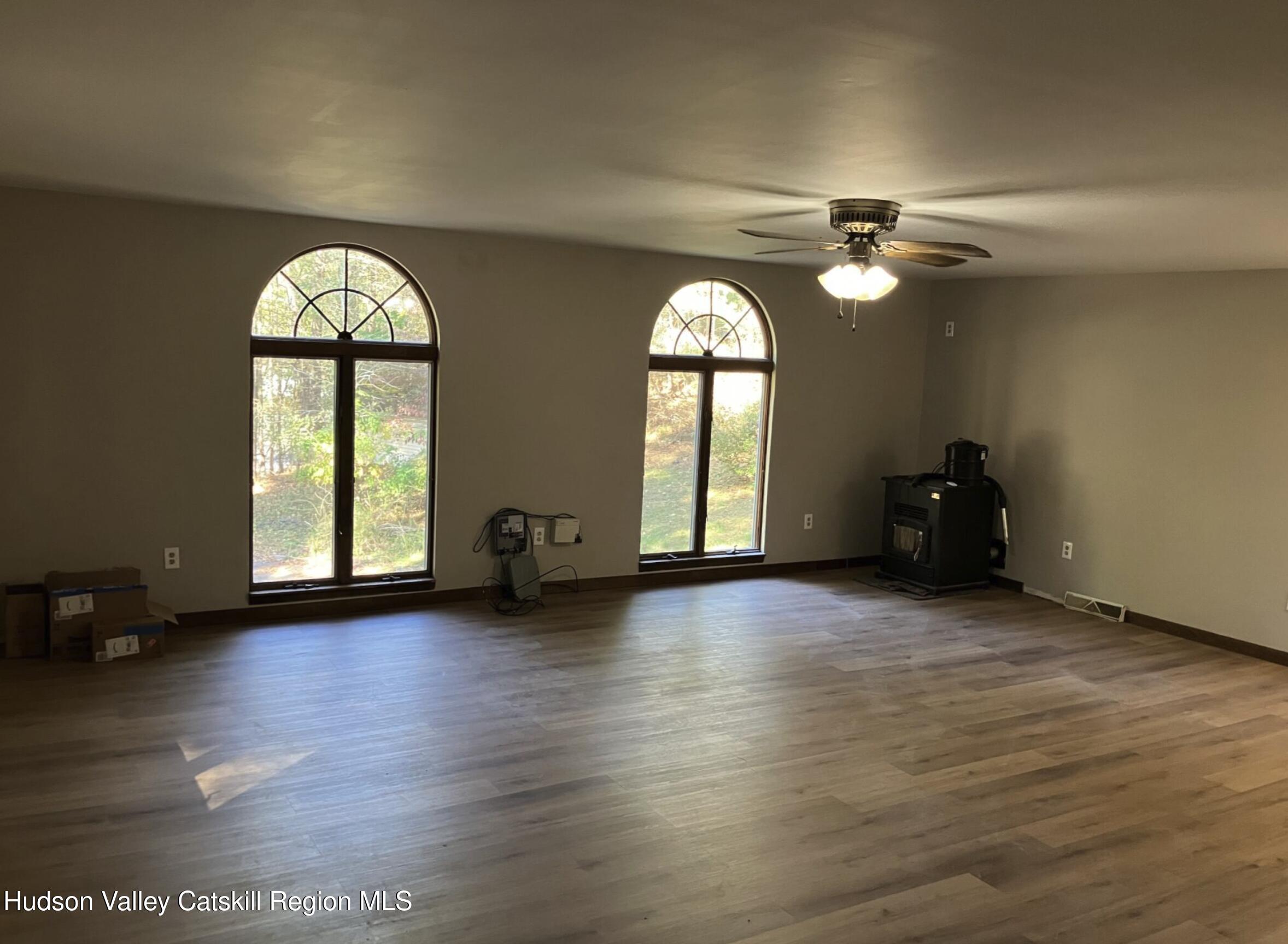 1072 Honey Hollow Road Earlton, NY 12058 - Photo 8 of 15 a view of empty room with wooden floor and fan