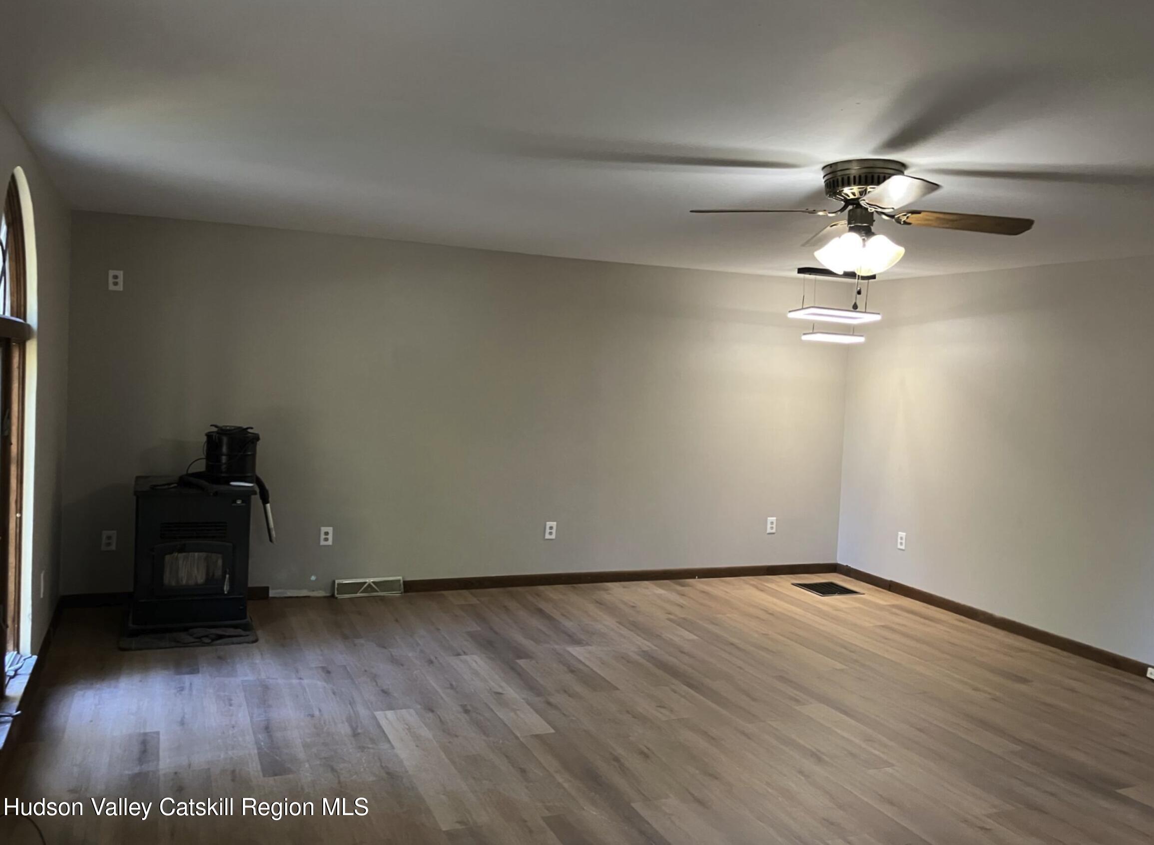 1072 Honey Hollow Road Earlton, NY 12058 - Photo 9 of 15 a view of empty room with wooden floor and fan