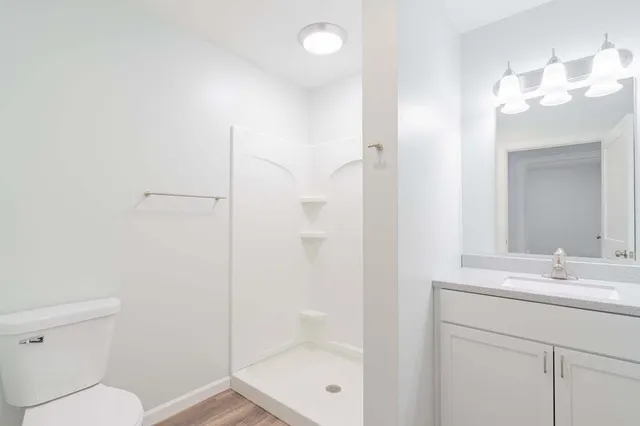 a bathroom with a sink a toilet and shower