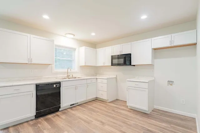 a kitchen with granite countertop white cabinets and white appliances