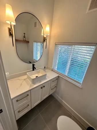 a bathroom with a sink mirror and toilet