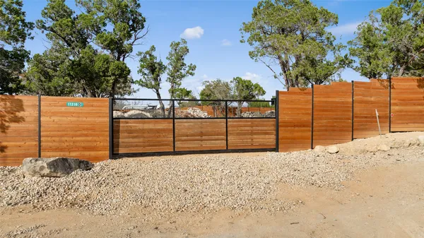 a view of a yard with wooden fence