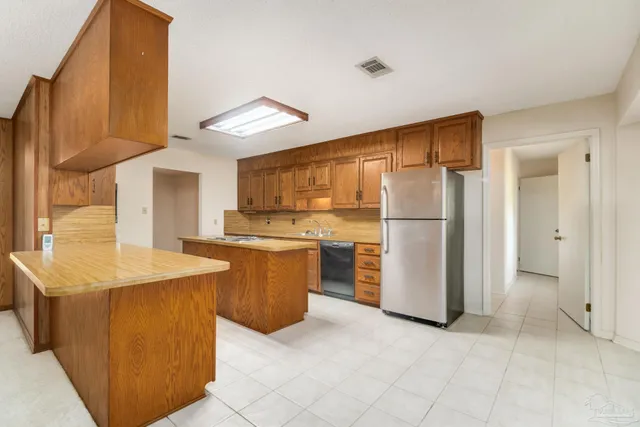 a view of a kitchen with a sink and a refrigerator