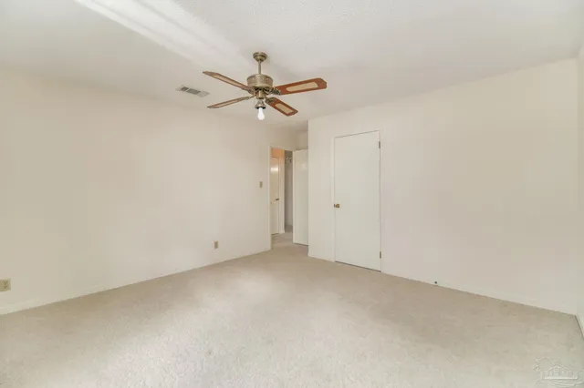 an empty room with a window and a ceiling fan