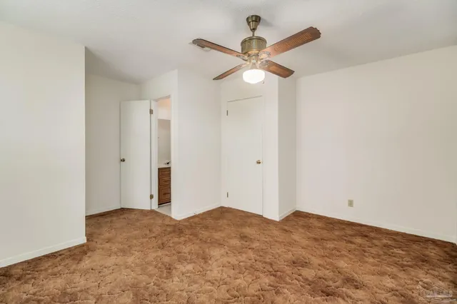 a view of an empty room with wooden floor and door