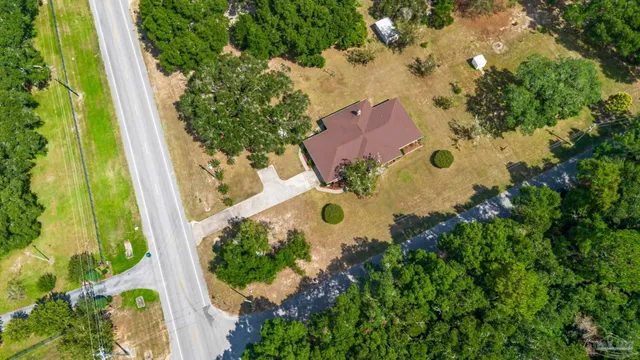 an aerial view of a house with a yard and garden