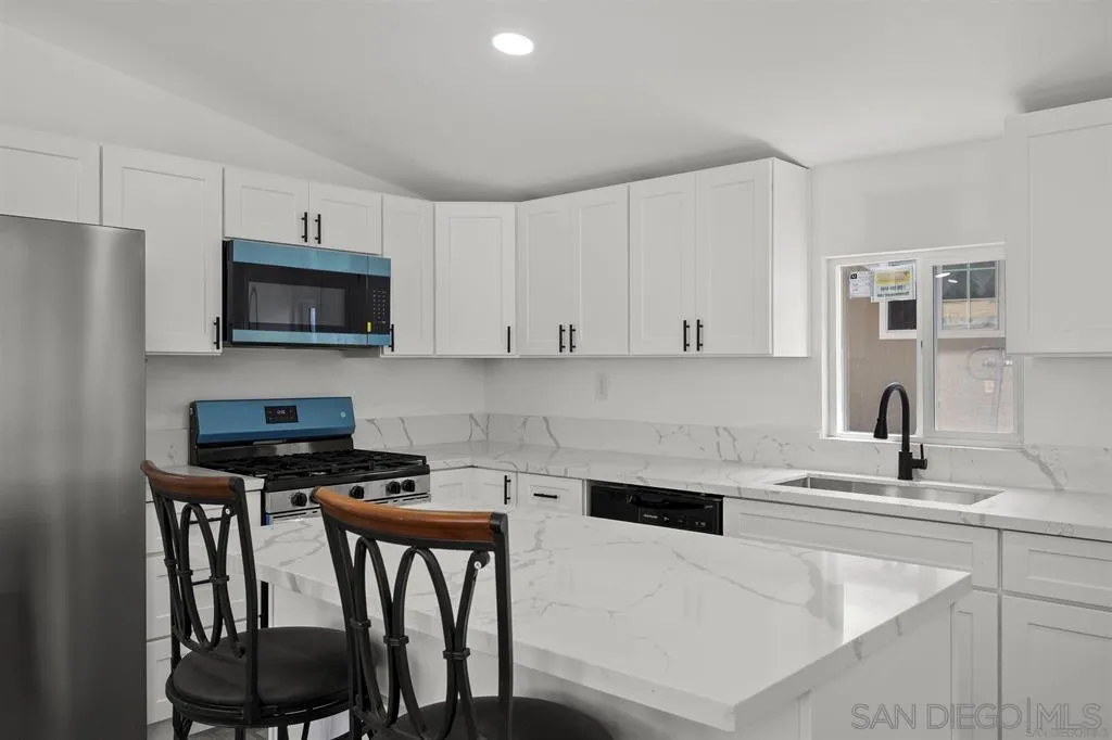 10767 Jamacha Boulevard, Unit SPC 62 Spring Valley, CA 91978 - Photo 8 of 25 a kitchen with stainless steel appliances a table chairs microwave and sink