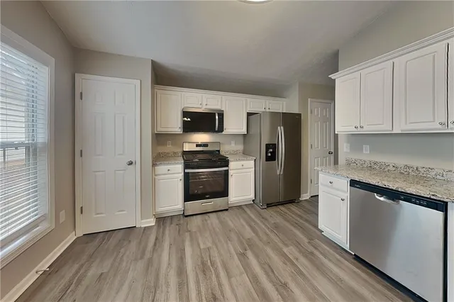 a kitchen with a refrigerator and a stove top oven
