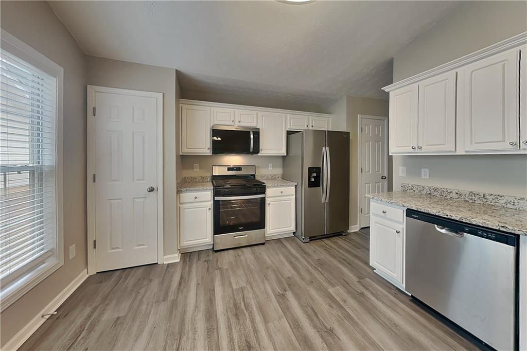 3318 Freedom Landing Northwest Kennesaw, GA 30144 - Photo 4 of 15 a kitchen with a refrigerator and a stove top oven