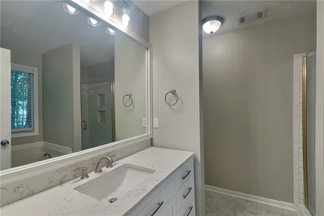 a bathroom with a sink shower and a mirror