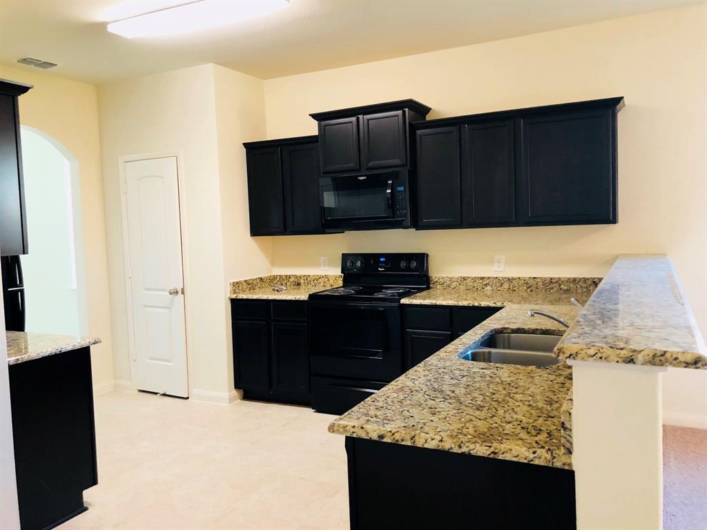 140 Curt Street Anna, TX 75409 - Photo 11 of 25 a kitchen with wooden cabinets and a sink