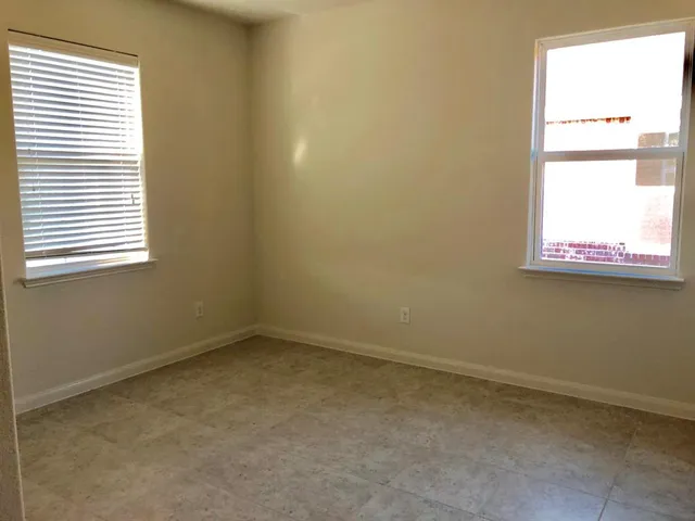 an empty room with closet and windows