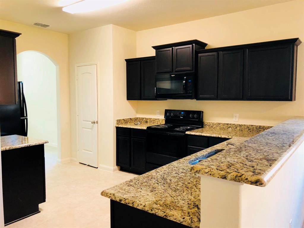 140 Curt Street Anna, TX 75409 - Photo 10 of 25 a kitchen with a sink and a refrigerator